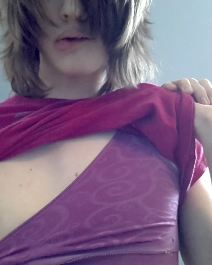 Femme en top rose déchiré montrant sa poitrine